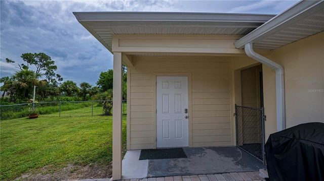 property entrance with a yard and fence