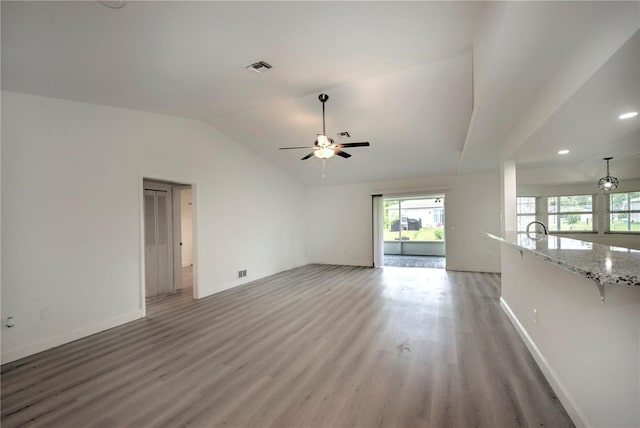 unfurnished living room featuring ceiling fan, vaulted ceiling, and hardwood / wood-style floors