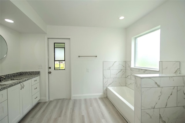 bathroom featuring a wealth of natural light, plus walk in shower, vanity, and hardwood / wood-style floors