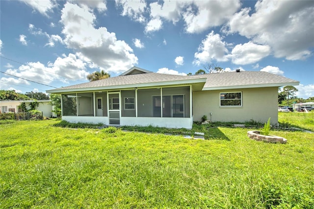 back of property featuring a sunroom and a yard