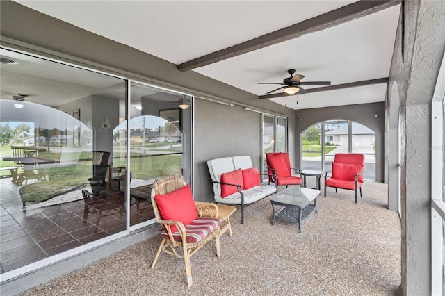 sunroom featuring ceiling fan and beam ceiling