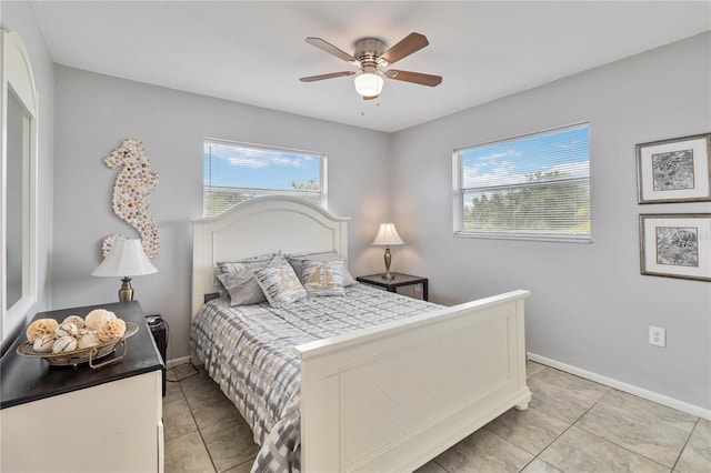 bedroom with ceiling fan, multiple windows, and light tile patterned floors