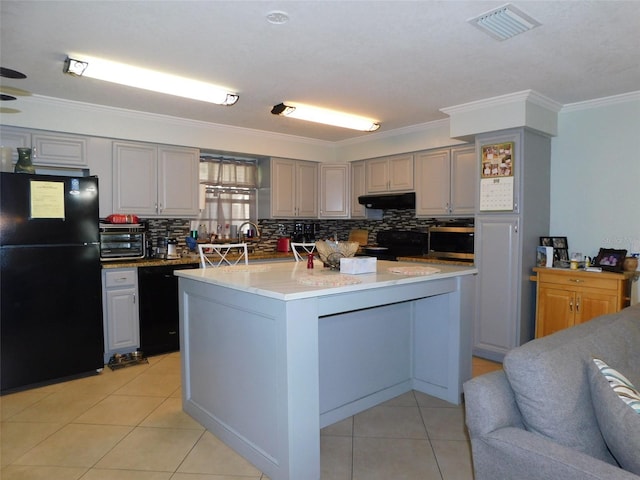 kitchen with backsplash, gray cabinets, black appliances, a center island, and light tile patterned flooring