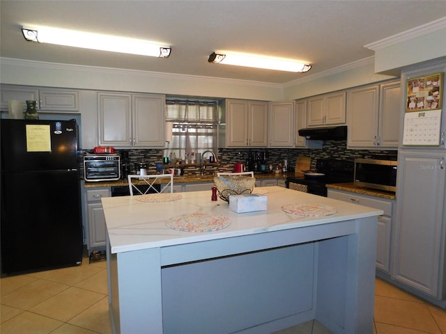 kitchen featuring a kitchen island, black refrigerator, electric stove, and gray cabinetry