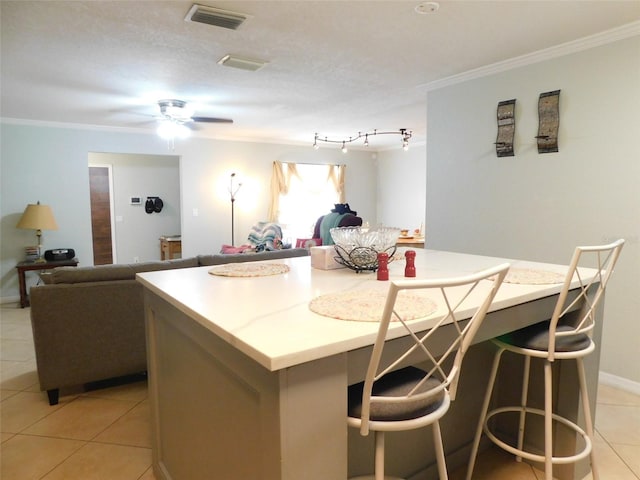 kitchen with rail lighting, a textured ceiling, light tile patterned floors, a kitchen island, and ceiling fan