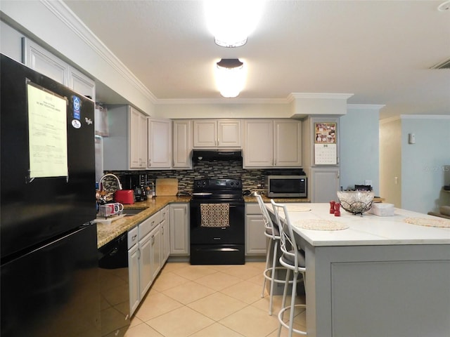 kitchen with tasteful backsplash, gray cabinets, extractor fan, and black appliances