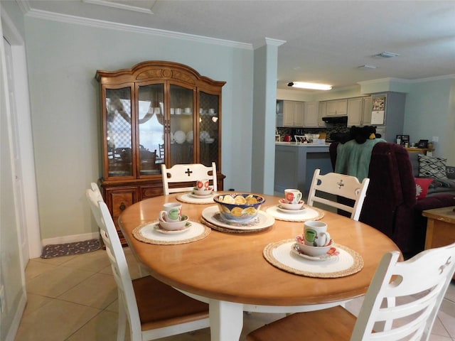 dining room with crown molding and light tile patterned floors