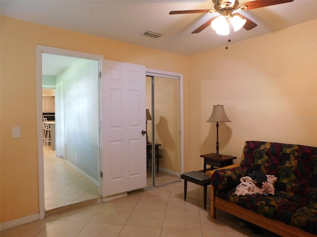 sitting room with ceiling fan and light tile patterned floors