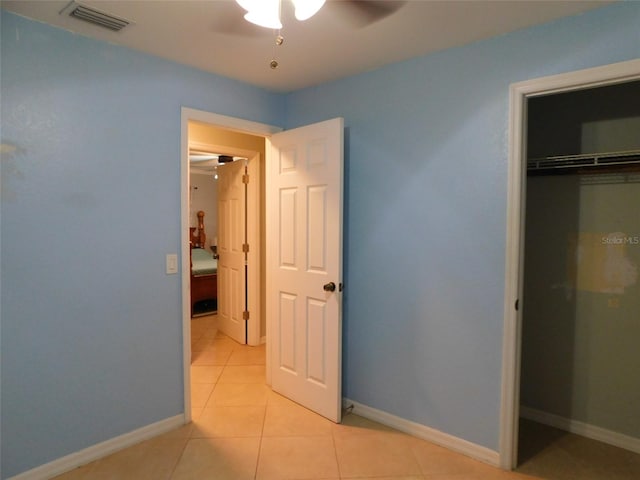 unfurnished bedroom featuring ceiling fan, a closet, and light tile patterned flooring