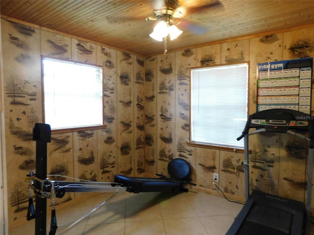 workout room with tile patterned flooring, ceiling fan, wooden ceiling, and wood walls