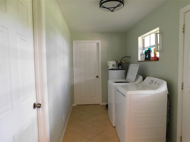 washroom with separate washer and dryer, light tile patterned floors, and water heater