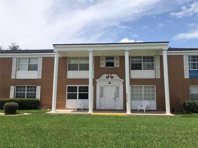 greek revival inspired property featuring a front lawn