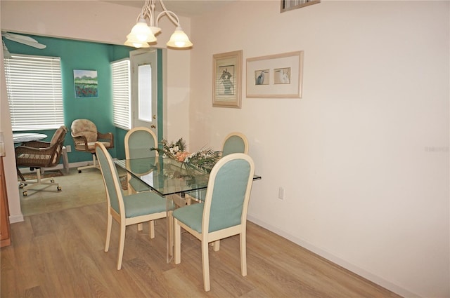 dining room with light hardwood / wood-style flooring and a chandelier