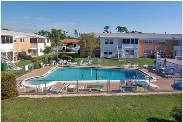 view of swimming pool featuring a patio area and a yard