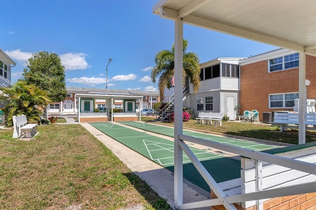 view of home's community featuring a lawn and shuffleboard