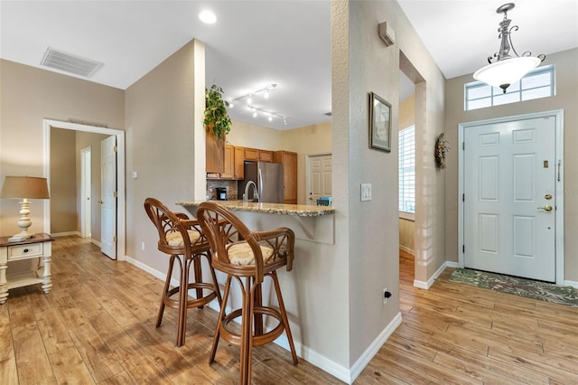 foyer entrance featuring light hardwood / wood-style floors and track lighting