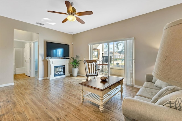 living room with light hardwood / wood-style floors and ceiling fan