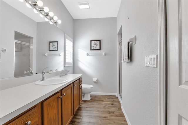 bathroom with toilet, vanity, and wood-type flooring