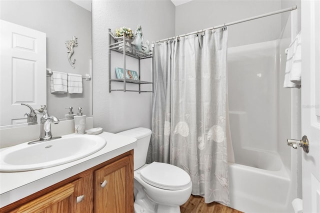 full bathroom with hardwood / wood-style flooring, toilet, shower / tub combo with curtain, and vanity