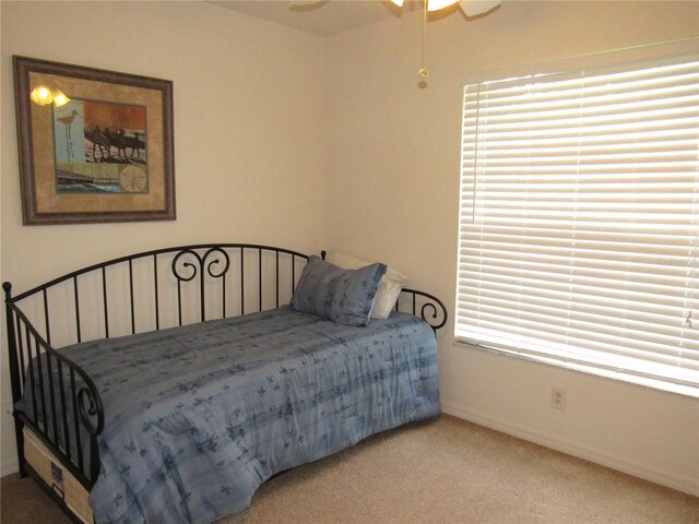 bedroom featuring ceiling fan, carpet, and multiple windows