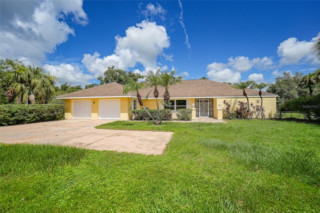 ranch-style home featuring an attached garage, driveway, a front yard, and stucco siding