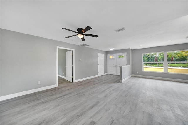 unfurnished living room with ceiling fan, light wood-style floors, visible vents, and baseboards