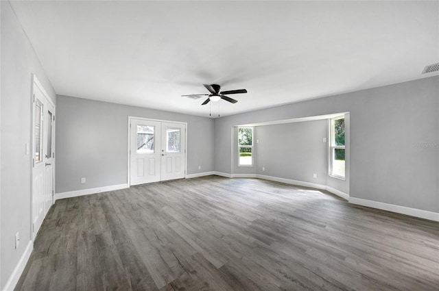 spare room with dark wood-style floors, visible vents, ceiling fan, and baseboards