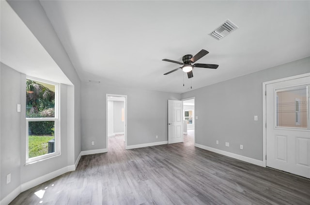 unfurnished bedroom featuring a ceiling fan, visible vents, baseboards, and wood finished floors