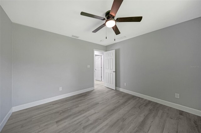 empty room with light hardwood / wood-style floors and ceiling fan