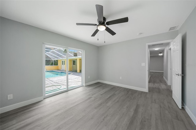 spare room with light wood-style floors, visible vents, and baseboards