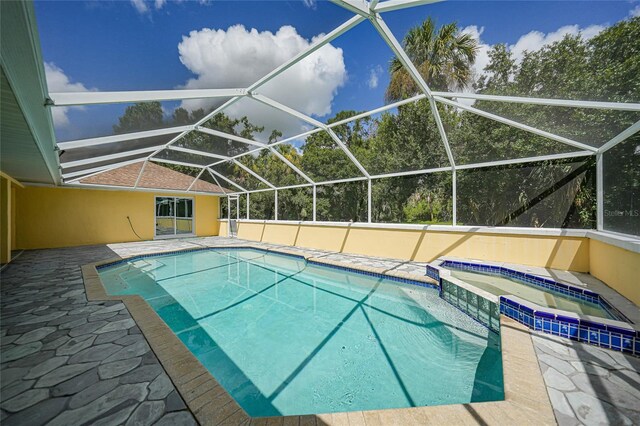 view of pool featuring a patio area, an in ground hot tub, and a lanai