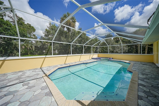 view of pool with glass enclosure and a patio area