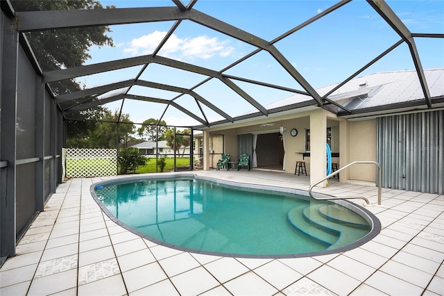 view of swimming pool featuring glass enclosure and a patio