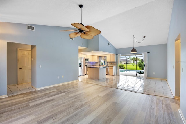 unfurnished living room with high vaulted ceiling, light hardwood / wood-style flooring, and ceiling fan