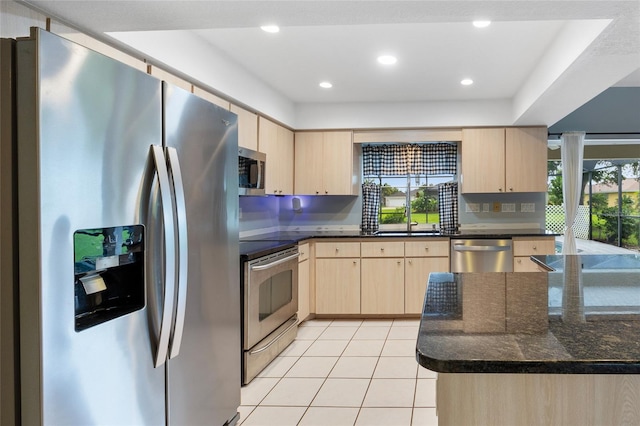 kitchen with light brown cabinets, a wealth of natural light, stainless steel appliances, and light tile patterned flooring