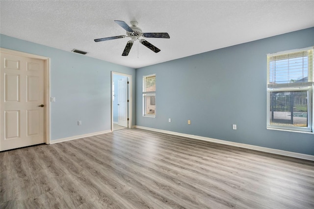 unfurnished room with a textured ceiling, light hardwood / wood-style flooring, and ceiling fan