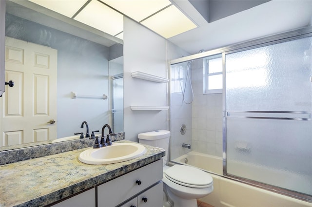 full bathroom featuring enclosed tub / shower combo, toilet, and vanity