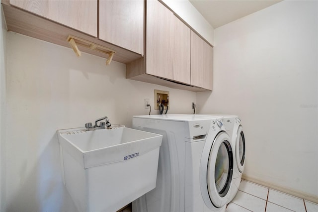 washroom with washer and clothes dryer, cabinets, sink, and light tile patterned flooring