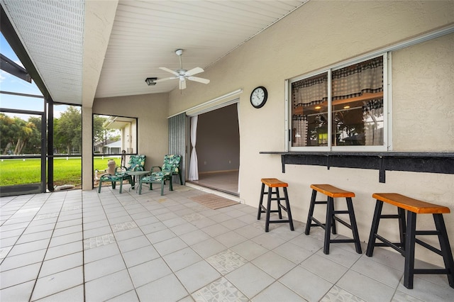 view of patio / terrace featuring glass enclosure and ceiling fan