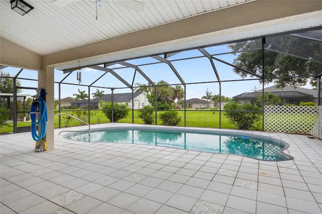 view of swimming pool with a lawn, a patio area, and a lanai