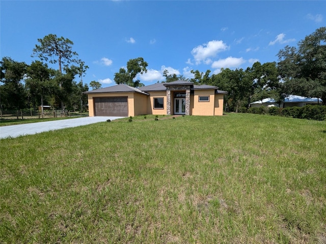 prairie-style home featuring a garage and a front lawn