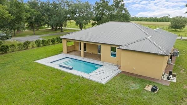 view of swimming pool featuring a yard, a patio, and a jacuzzi