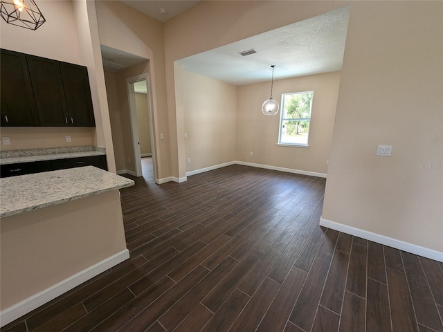 interior space featuring a textured ceiling and dark hardwood / wood-style floors