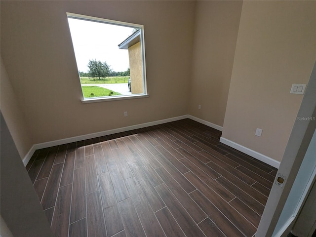 empty room with baseboards and wood tiled floor