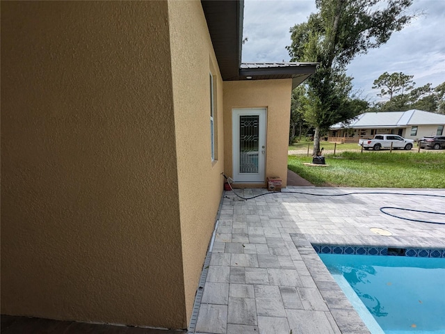 view of swimming pool featuring a patio area and a lawn
