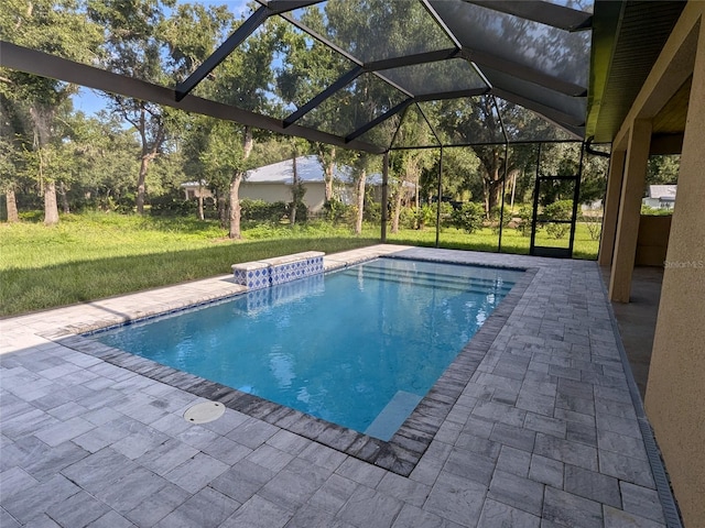 view of pool with a yard, a lanai, pool water feature, and a patio area