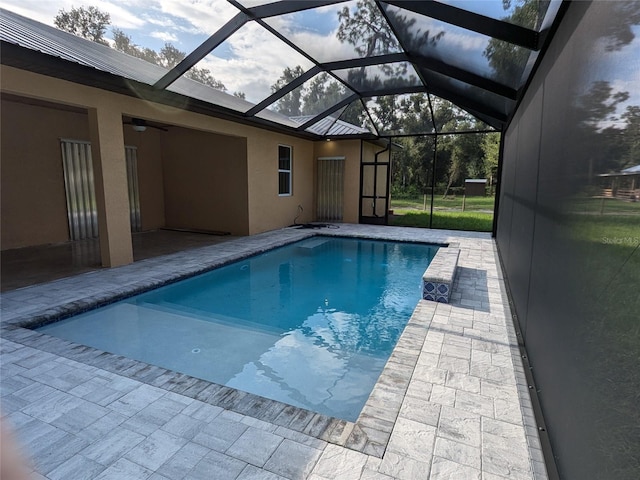outdoor pool featuring a lanai, ceiling fan, and a patio