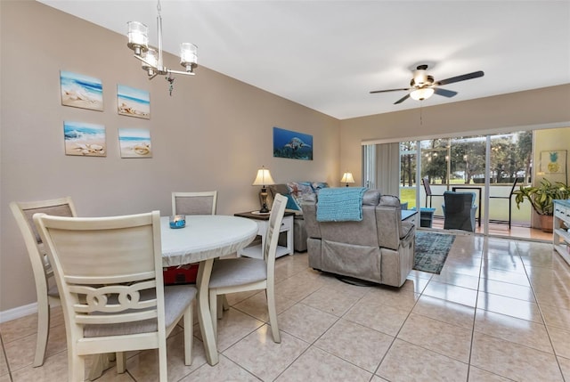 dining space with ceiling fan with notable chandelier and light tile patterned floors