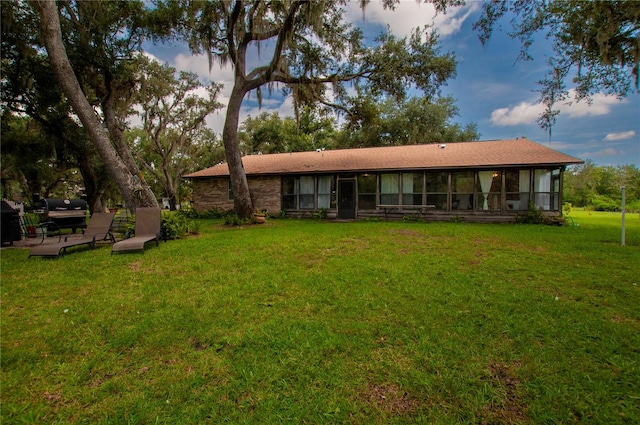 rear view of property featuring a lawn