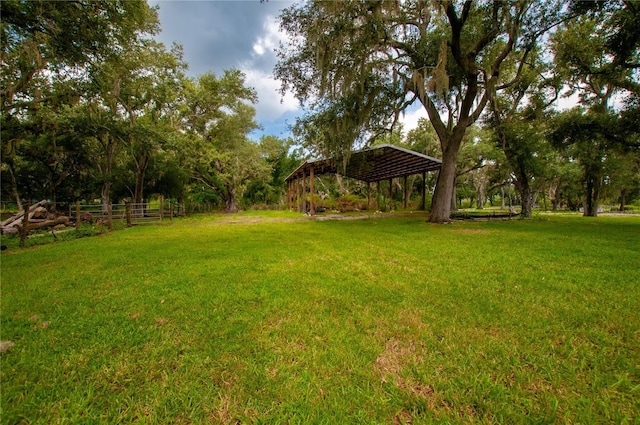 view of yard with fence and a detached carport